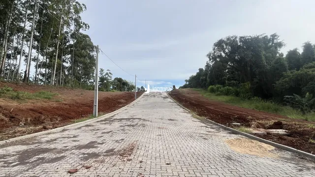 Uma estrada pavimentada se estende por uma área de terra com vegetação ao redor.