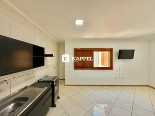 Foto de uma cozinha com bancada e televisão montada na parede.