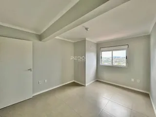 Ambiente interno de uma sala com paredes brancas e piso claro.