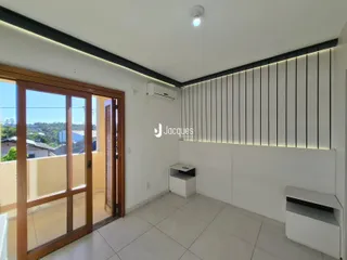 Sala de estar com porta de vidro e parede de destaque em um imóvel em Lajeado.