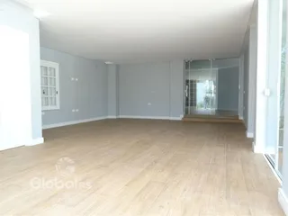 Ambiente interno de uma sala com piso de madeira clara.