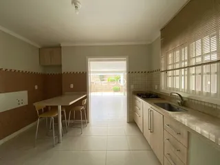 Ambiente interno de uma sala de jantar com cozinha em uma residência no Brasil.