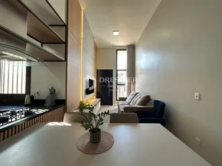 Vista interna de uma sala de estar com cozinha em um imóvel em Lajeado.
