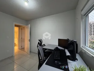 Ambiente interno de um escritório com mesa e janela em um imóvel no Brasil.