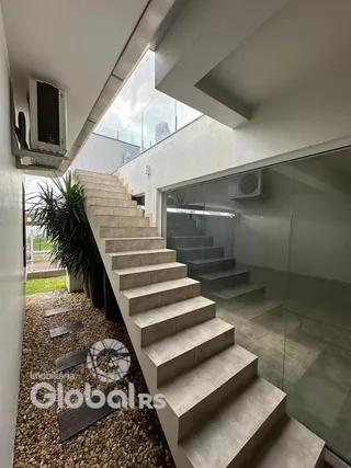 A foto mostra a fachada de uma residência com escadarias externas.