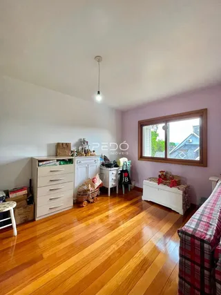 Sala de estar com piso de madeira e janela grande.