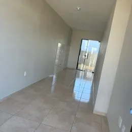 Hall de corredor com piso de cerâmica claro.