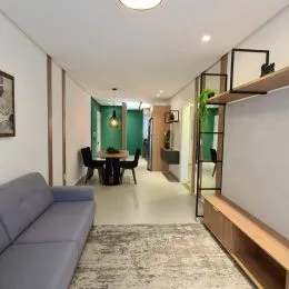 Hall de entrada com sofá e estante de madeira.