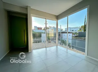 Ambiente interno com portas de vidro abrindo para uma área externa pavimentada.
