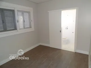 Foto de um ambiente interno com piso de madeira clara e janela.