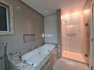 Foto de um banheiro com banheira e revestimento de mármore.