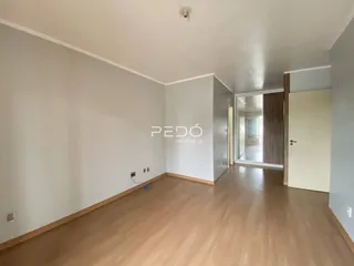 Hall de entrada com piso de madeira clara e paredes brancas.