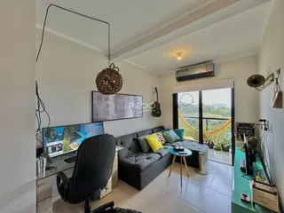 Sala de estar com sofá e vista para o exterior.