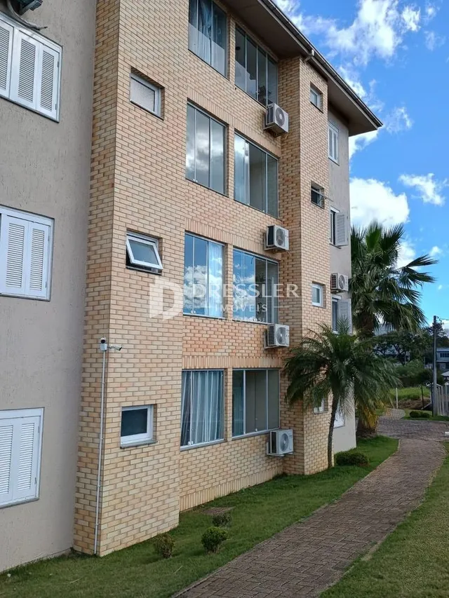 Fachada de um prédio residencial em Lajeado, Brasil, com janelas e unidades externas de ar-condicionado.