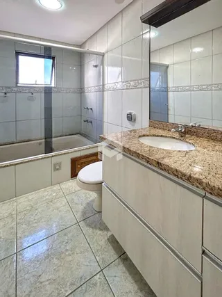 Foto de um banheiro com piso de cerâmica e banheira em um imóvel no Brasil.