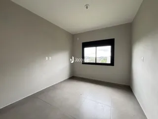 Interior de um ambiente com paredes brancas e piso claro.