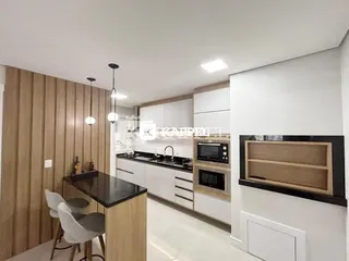 Foto de uma cozinha com armários e bancada escura em um ambiente com painéis de madeira.