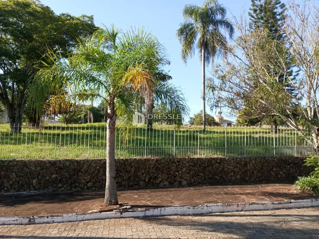 Vista da propriedade com cerca e muro de pedra no exterior.