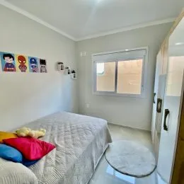 Um quarto com cama e quadros decorativos em uma residência.