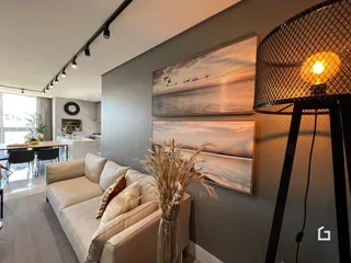 Sala de estar com sofá e arte na parede.