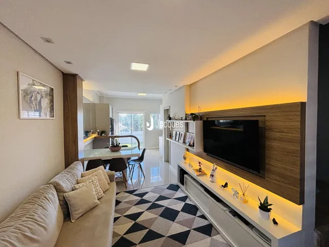 Sala de estar com sofá e painel de TV em um imóvel no Brasil.