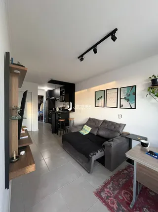 Sala de estar com sofá e piso de cerâmica.