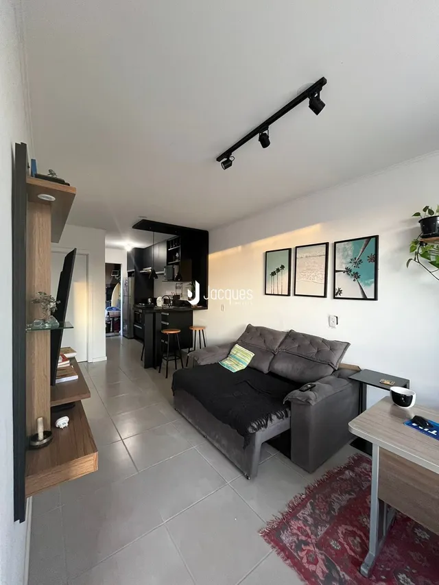 Sala de estar com sofá e piso de cerâmica.