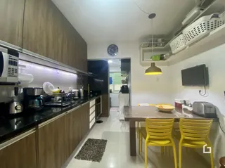 Cozinha com armários de madeira e bancadas escuras.