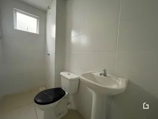Banheiro com paredes brancas e revestimento cerâmico.