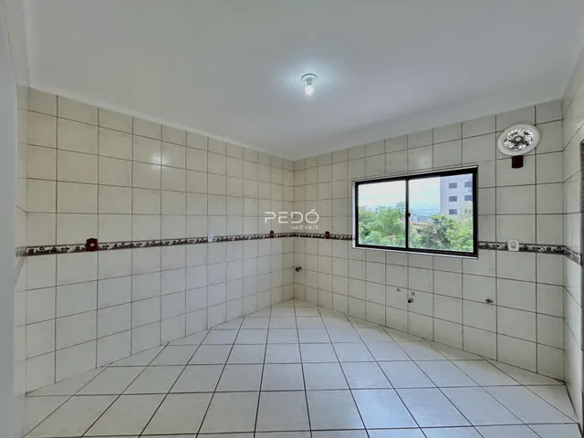 Vista interna de um corredor com piso de cerâmica branca.