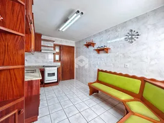 Uma sala de estar com piso de cerâmica e móveis de madeira.