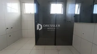 Corredor interno com piso e paredes revestidos em cerâmica branca.