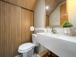 Banheiro com bancada branca e painéis de madeira na parede.
