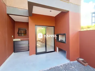 Fachada da residência em Lajeado, Brasil, mostrando a entrada com porta de vidro e garagem.