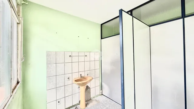 Foto de um ambiente interno com paredes verdes e azulejos brancos.