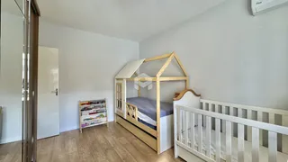 O quarto apresenta uma cama de beliche de madeira e piso de madeira clara.