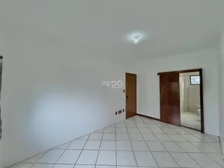 Hall de entrada com paredes brancas e piso de cerâmica.