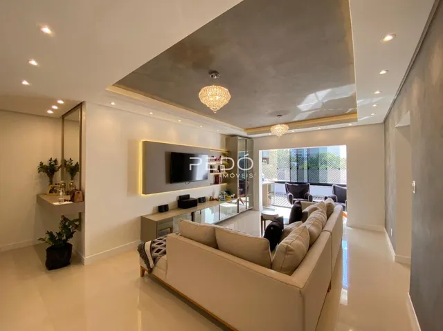 Sala de estar moderna com piso claro e grandes portas de vidro.