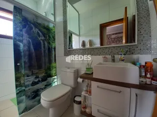 Foto de um banheiro com azulejos brancos e louças sanitárias.