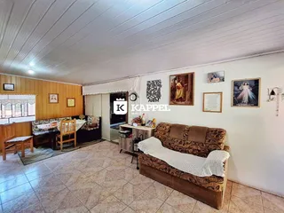 Sala de estar com sofá e área de jantar em um imóvel residencial.
