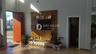 Sala de estar com piso de madeira e parede de destaque em um imóvel no Brasil.