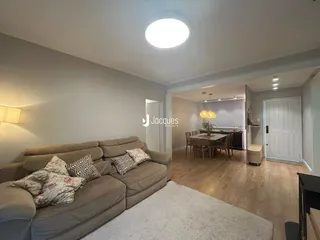 Foto da sala de estar com sofá e piso de madeira.
