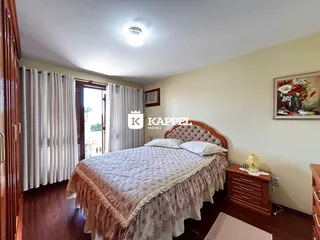 Quarto com cama de casal e piso de madeira.