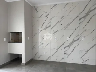 Parede revestida com azulejos de mármore cinza e branco em um ambiente interno.