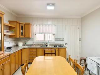 Foto de uma cozinha com armários de madeira e mesa de jantar.