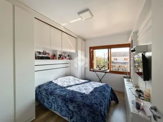Quarto com armários embutidos e janela de madeira.