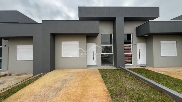 Fachada moderna de uma residência em Lajeado, Brasil, com revestimento cinza.
