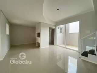 Uma sala de estar ampla e iluminada com piso claro.