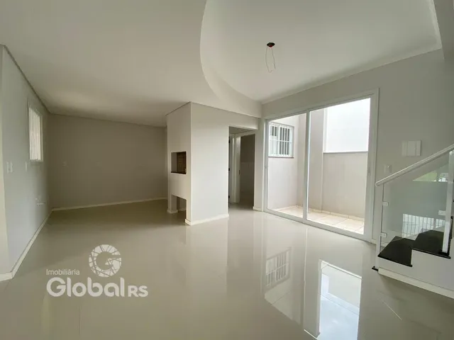 Uma sala de estar ampla e iluminada com piso claro.