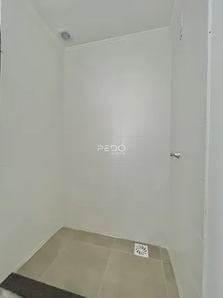 Foto do interior de um banheiro com revestimento cerâmico nas paredes e piso.